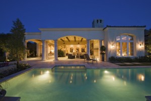 Lit swimming pool and building exterior at night